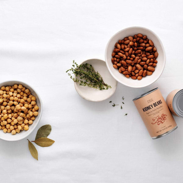 bowl of garbanzo beans, bowl of kidney beans, herbs, can of kidney beans