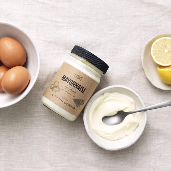 bowl of cage free eggs, jar of organic mayonnaise, bowl of mayonnaise with spoon, halved lemons