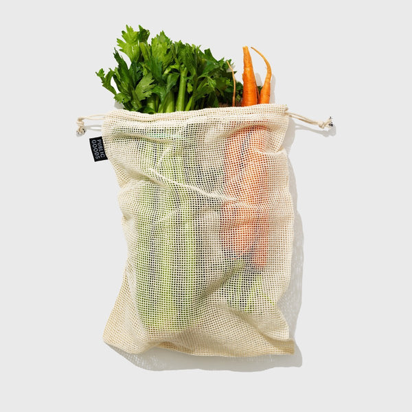 reusable mesh grocery bag filled with carrots and celery stalks